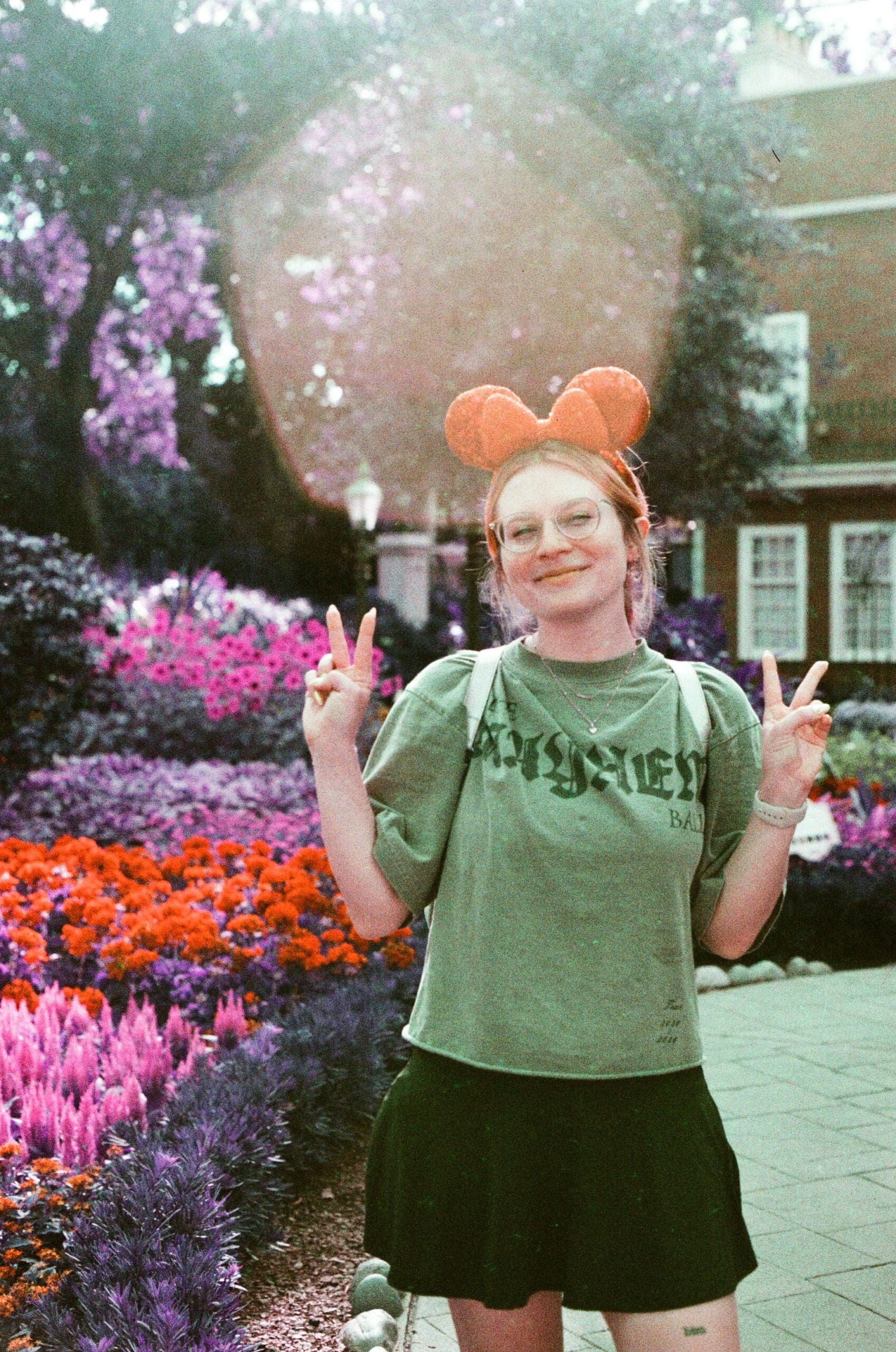 Person in front of Epcot Flower and Garden Festival gardens on LomoChrome Purple film